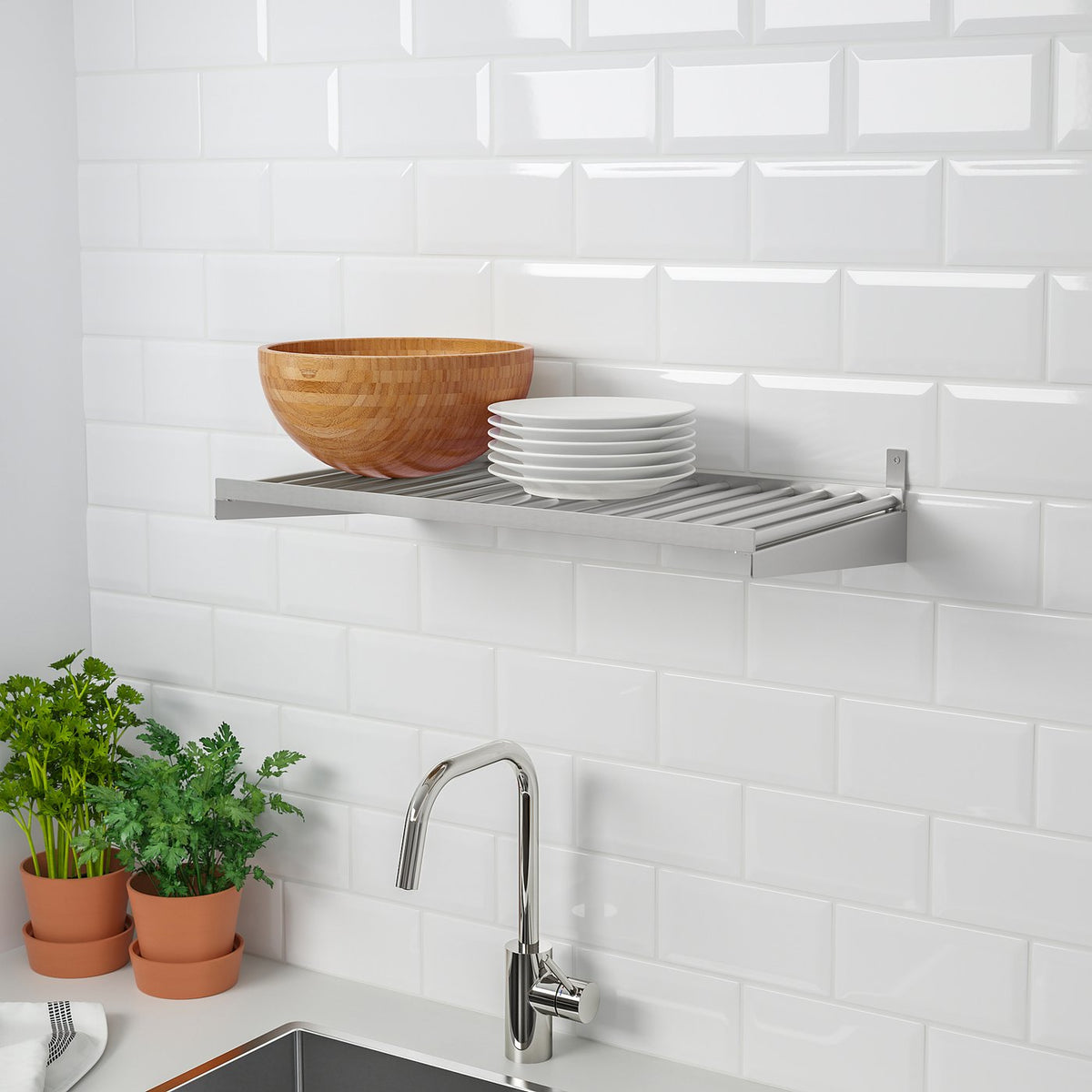 Kitchen scene with KUNGSFORS shelf, bowl, plates, tap, and herbs.