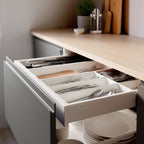 Open kitchen drawer with white UPPDATERA cutlery tray. Trays store and organise utensils neatly.