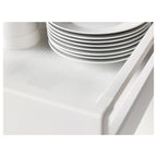 Stack of white plates on a perforated drawer mat. The mat protects shelves and dampens noise.
